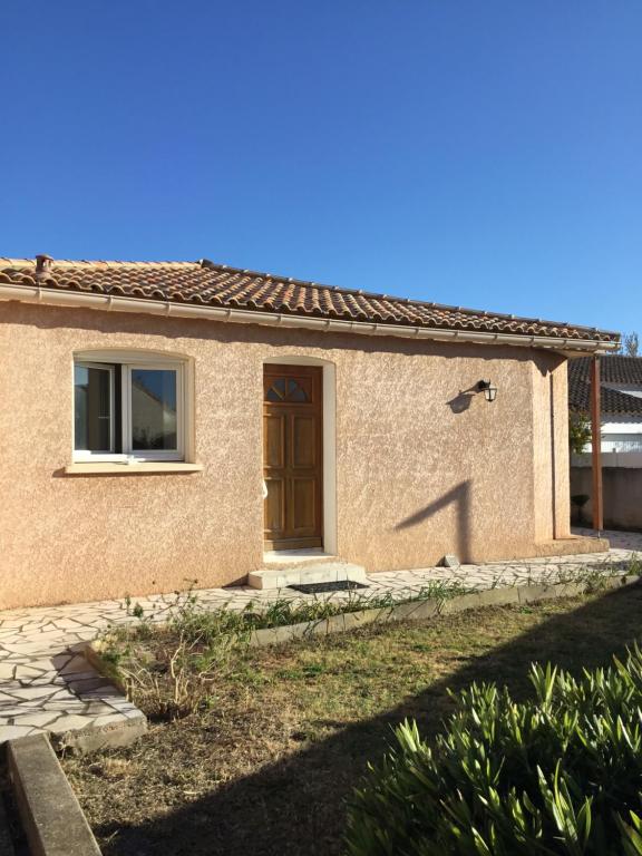 a house with a brown door in a yard at Marseillan in Marseillan