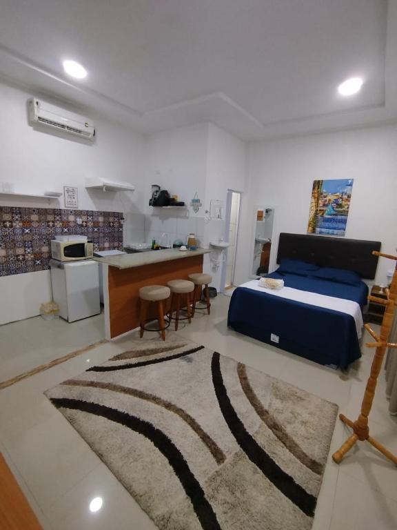 a bedroom with a bed and a kitchen with a counter at Durmaaquislz in São Luís