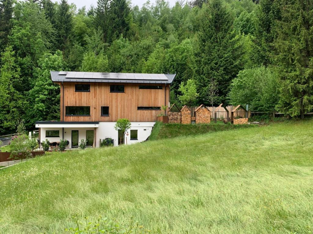 een huis op een heuvel met een groen veld bij Waldblick - Neubau - Self-Check-In - kein Verkehr - am Wald - Parkplätze vor Tür - apartment or double room in Innsbruck