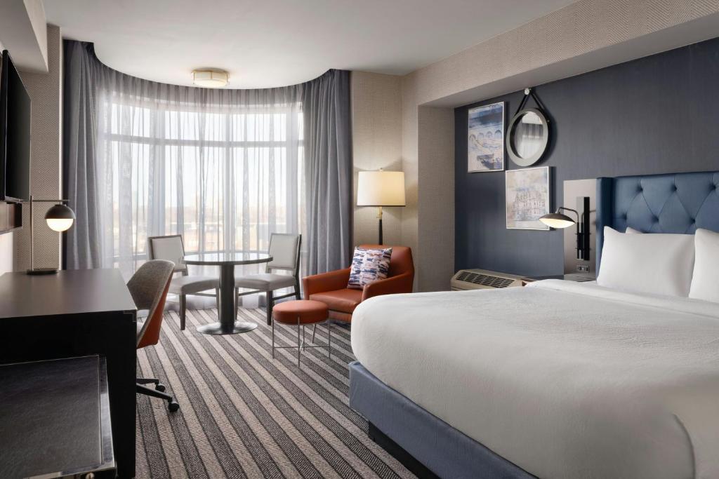 a hotel room with a large bed and a desk at Courtyard by Marriott Boston Brookline in Brookline