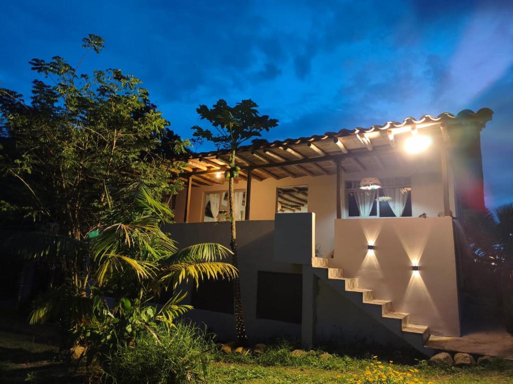a house with lights on the side of it at Hospedaje Finca Eje Cafetero, Casa Ne u in Marsella