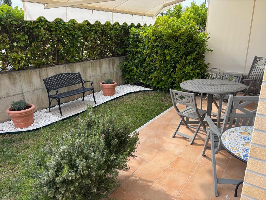 a patio with a table and chairs in a yard at Appartamento Verde Golf in Miglianico