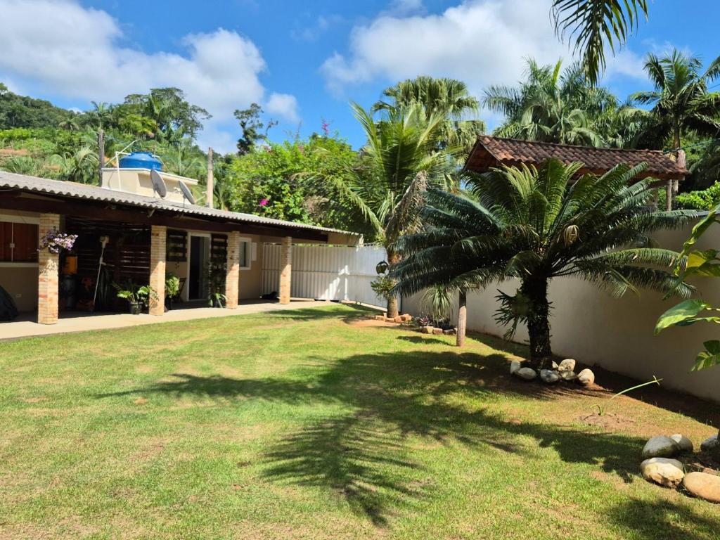 a yard in front of a house with a palm tree at Pousada da Aline in Sete Barras