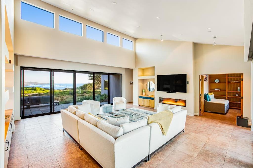 a large living room with a couch and a tv at Seaspray in Sea Ranch