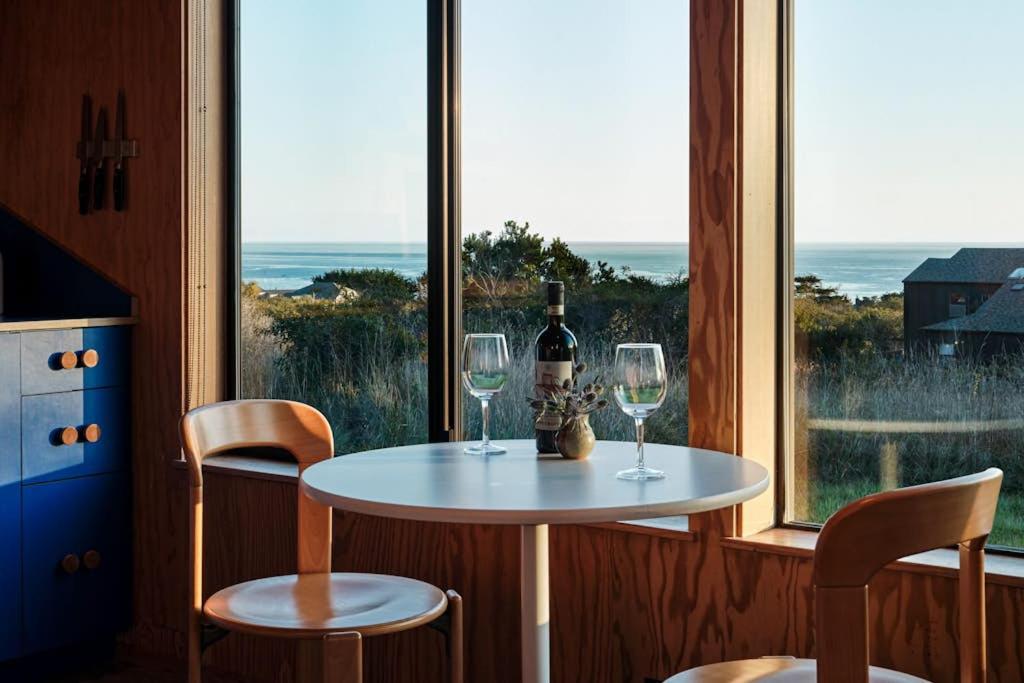 a table with a bottle of wine and two glasses at Wild Meadow in Sea Ranch