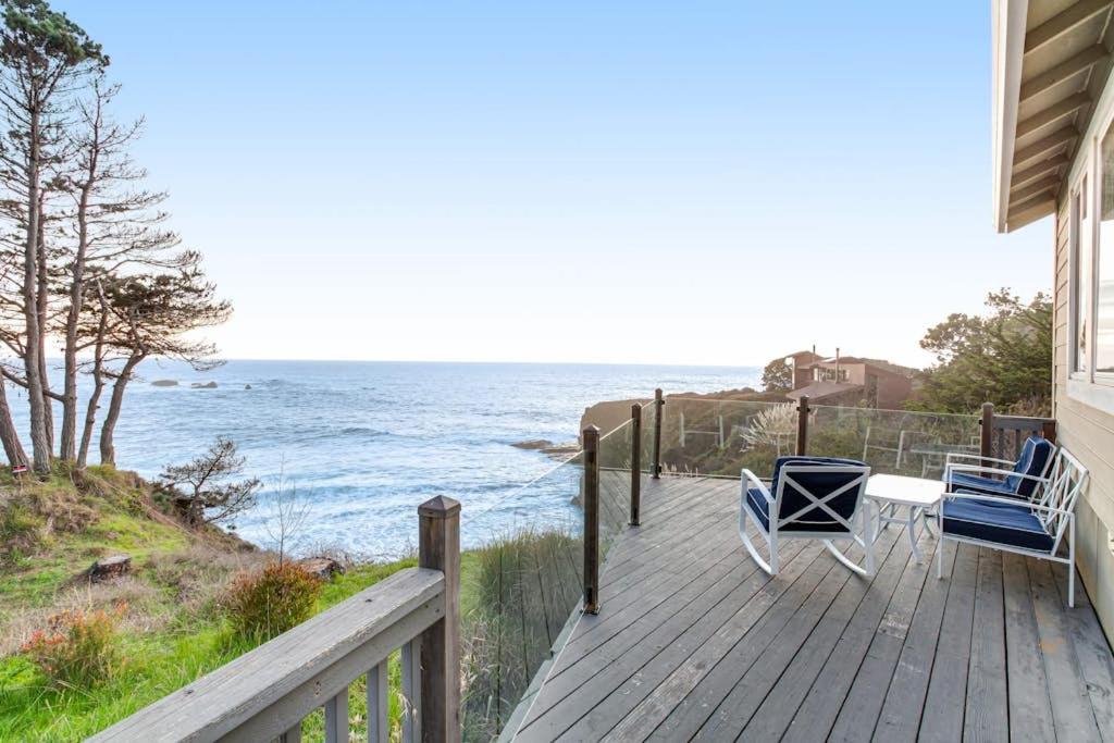 a porch with chairs and a table and the ocean at Otter's Rest in Gualala
