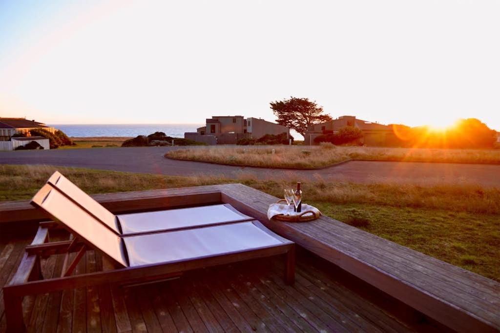 a wooden bench with a table and a glass of wine at Da Yaya House in Sea Ranch