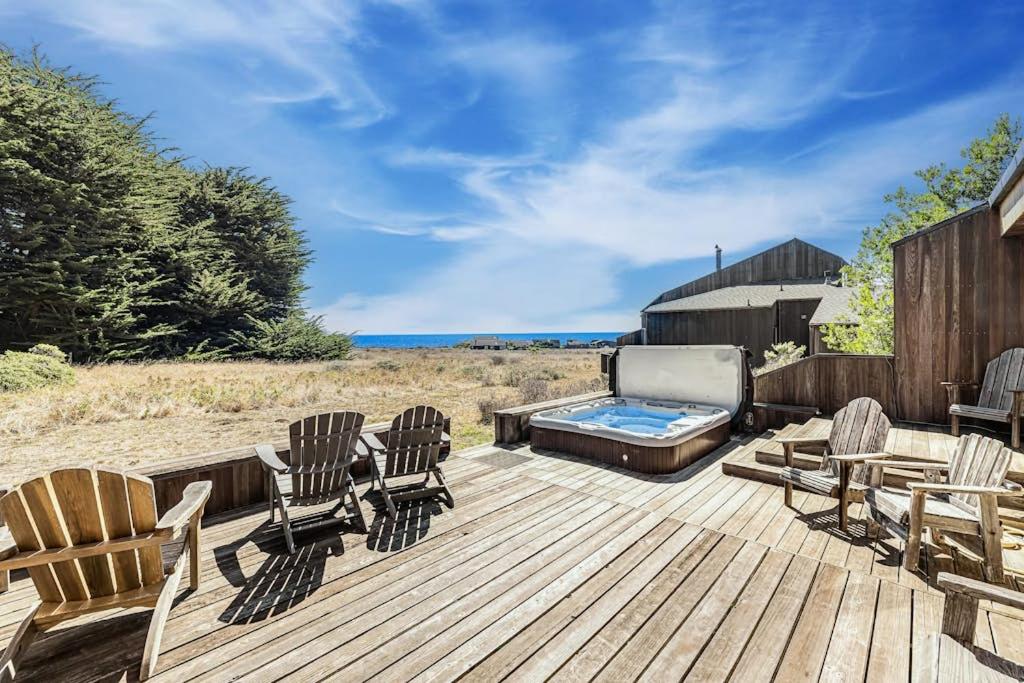 a deck with rocking chairs and a hot tub at Urban Escape Compound in Sea Ranch