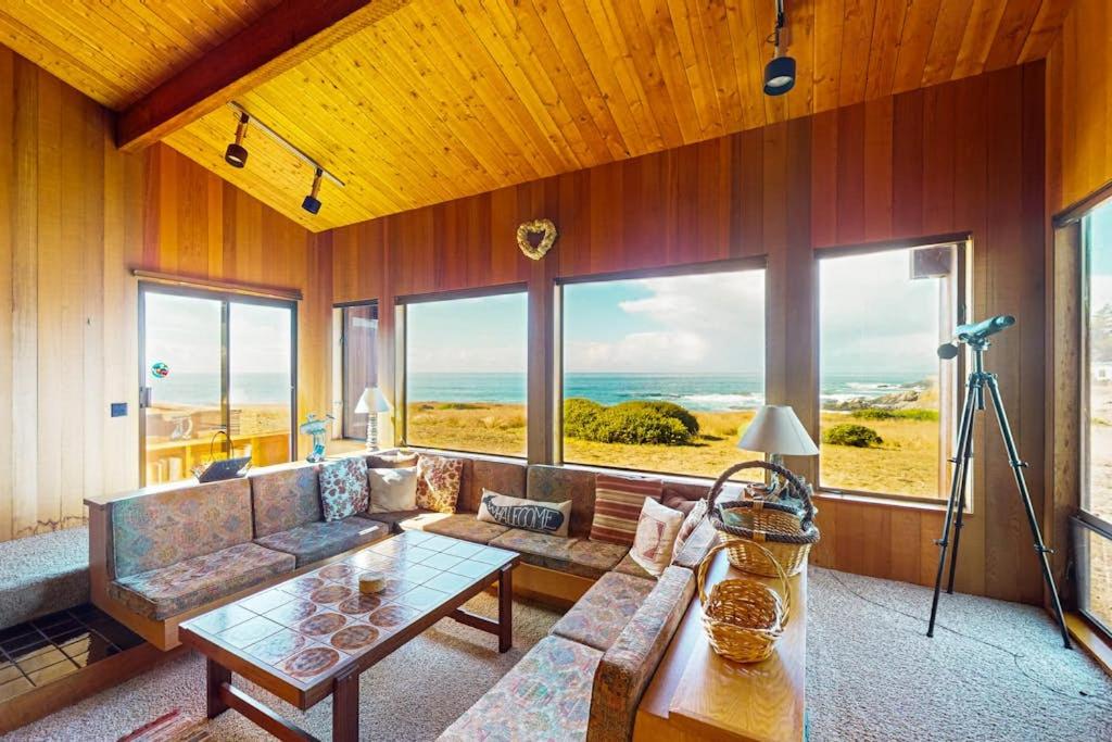 a living room with a couch and a large window at Touch the Tides in Sea Ranch