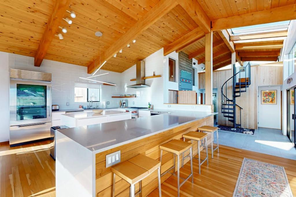a large kitchen with a large counter and wooden ceilings at Coffee by the Sea in Sea Ranch
