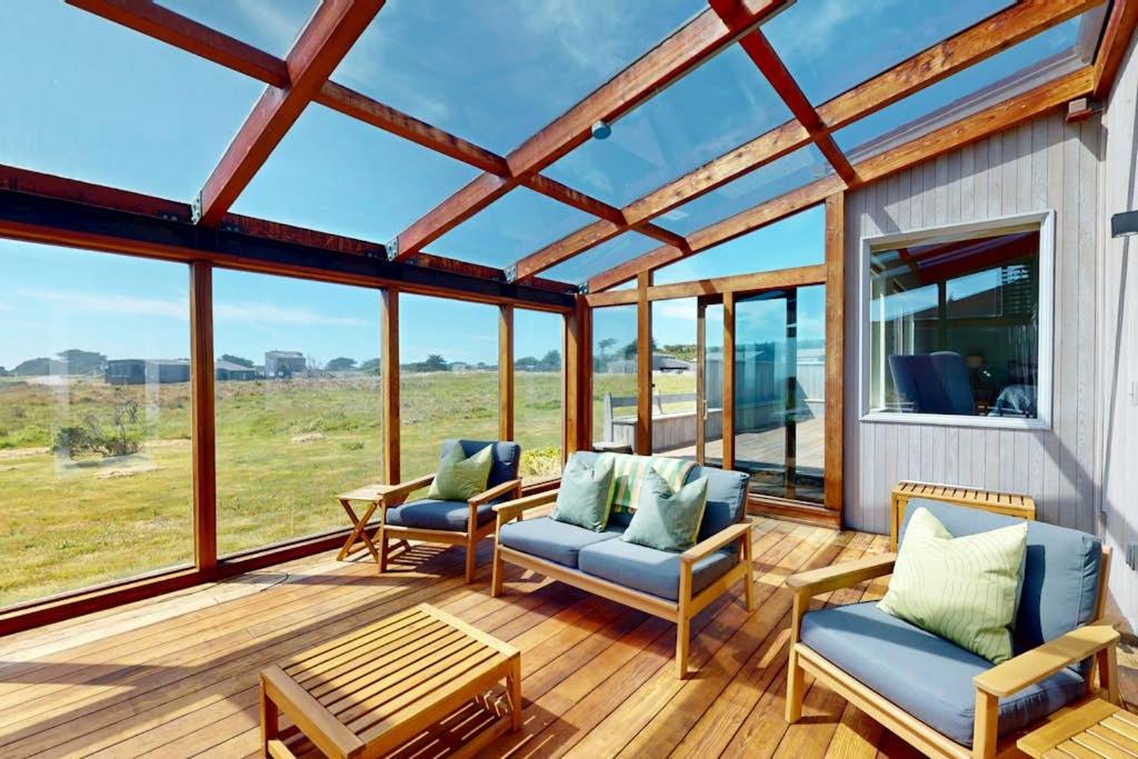 a screened in porch with chairs and a table at Elizabeth Dane in Sea Ranch