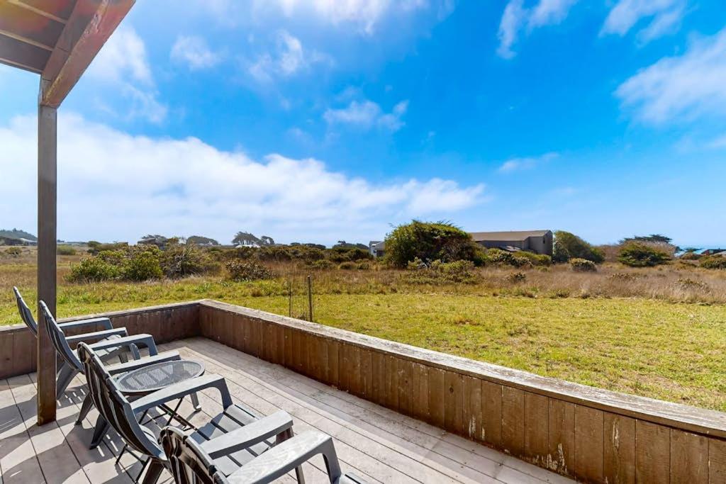a deck with chairs and a view of a field at Blue Mermaid in Sea Ranch