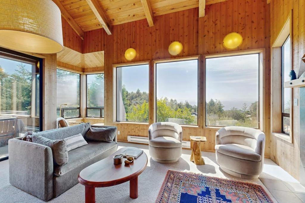 a living room with a couch and chairs and windows at Timber & Tide in Sea Ranch