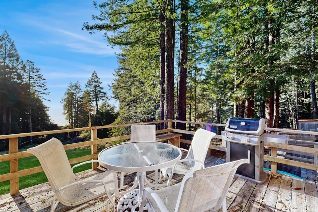 a table and chairs on a deck with a grill at Schooner in Sea Ranch