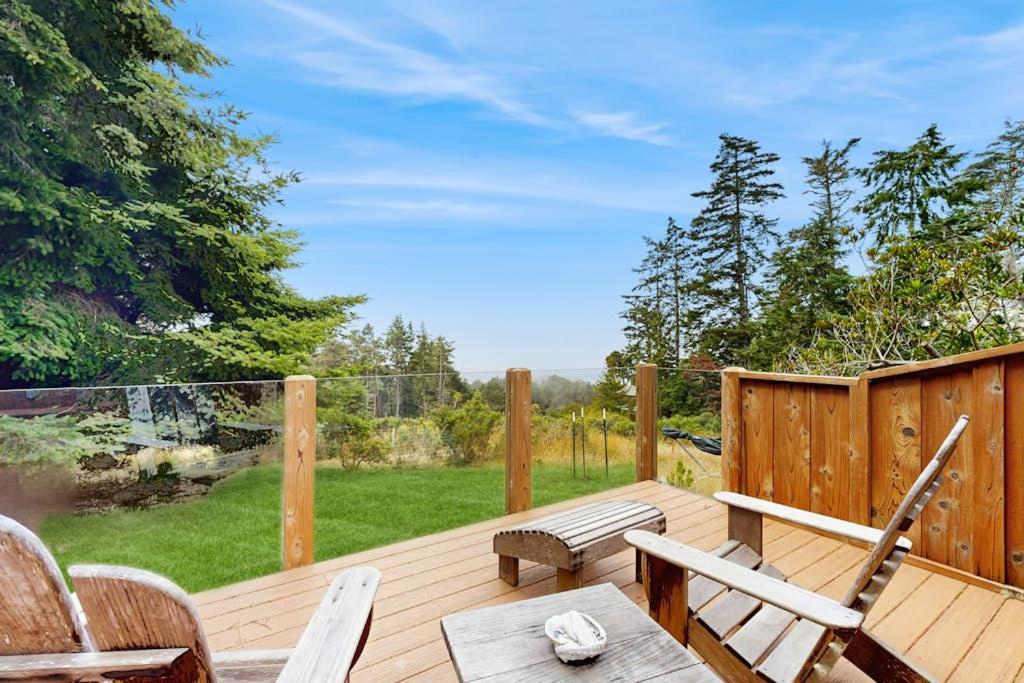 a wooden deck with chairs and a bench on it at Cypress Cove in Sea Ranch