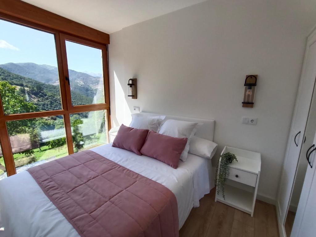 a bedroom with a bed with a large window at Casamor in Tollo