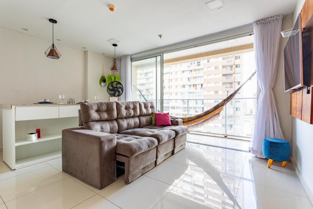 a living room with a couch and a large window at AP Df Plaza varandão in Brasília