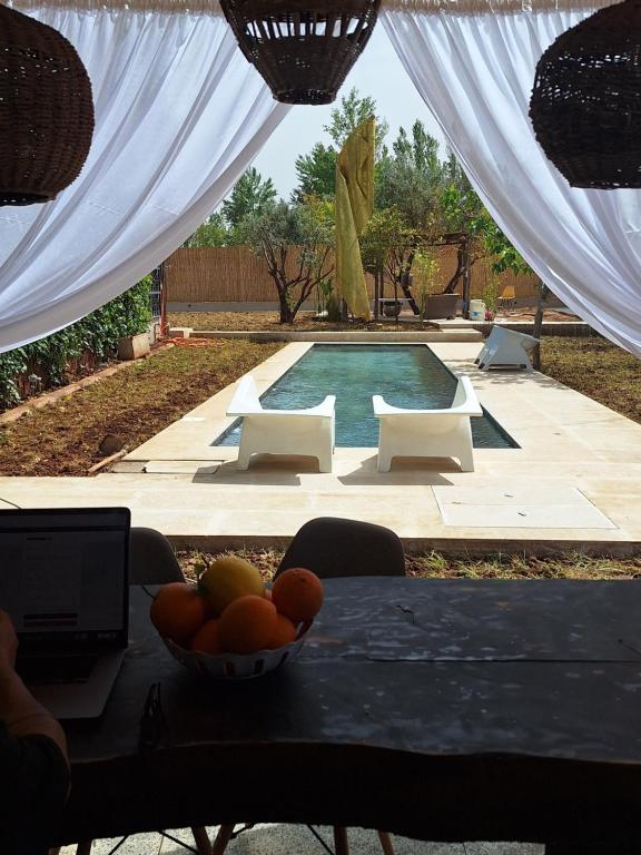 a bowl of fruit on a table in front of a pool at loft B in Fez