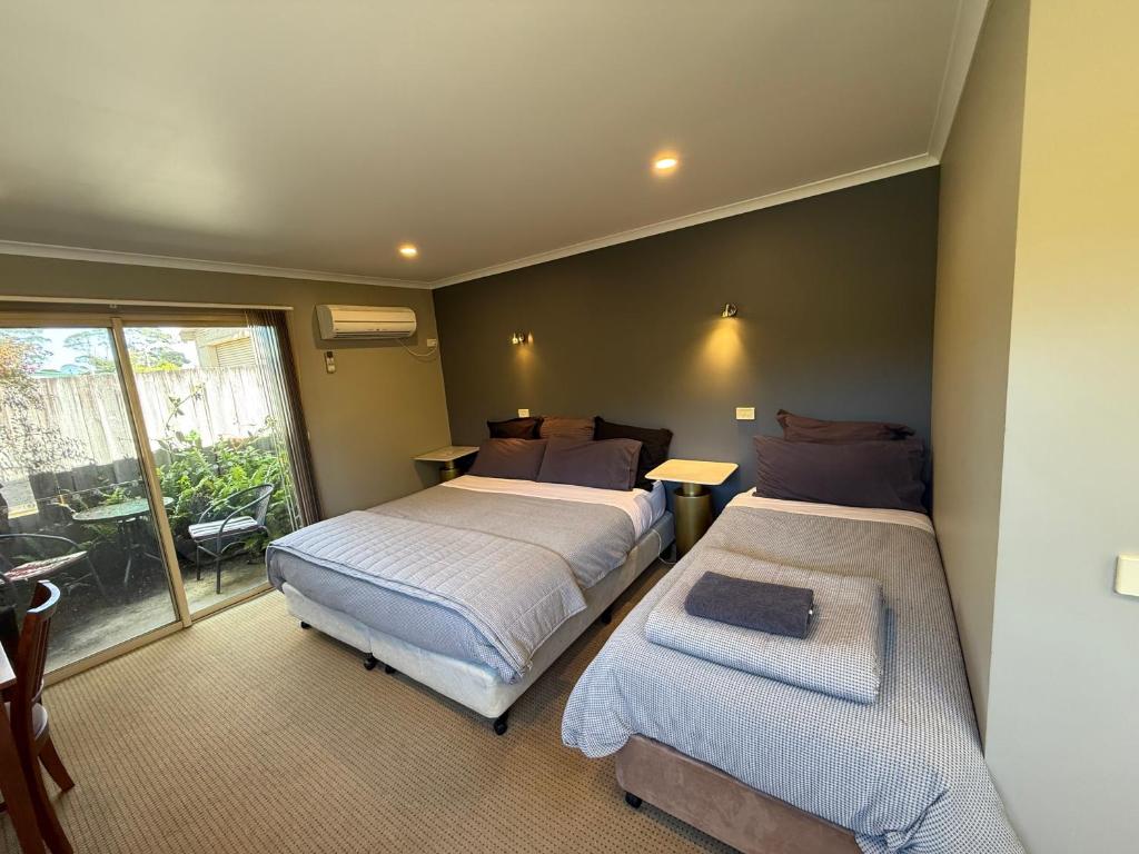 a hotel room with two beds and a balcony at Motel Strahan in Strahan
