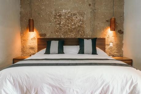 a bedroom with a white bed with two pillows at El Mesón de Don José in La Mesa