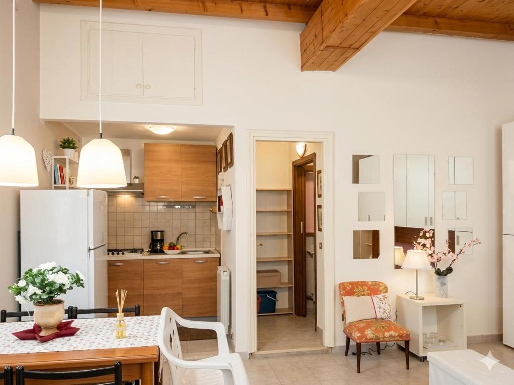 a kitchen with white cabinets and a table and chairs at a casa di Max in Trezzo sullʼAdda