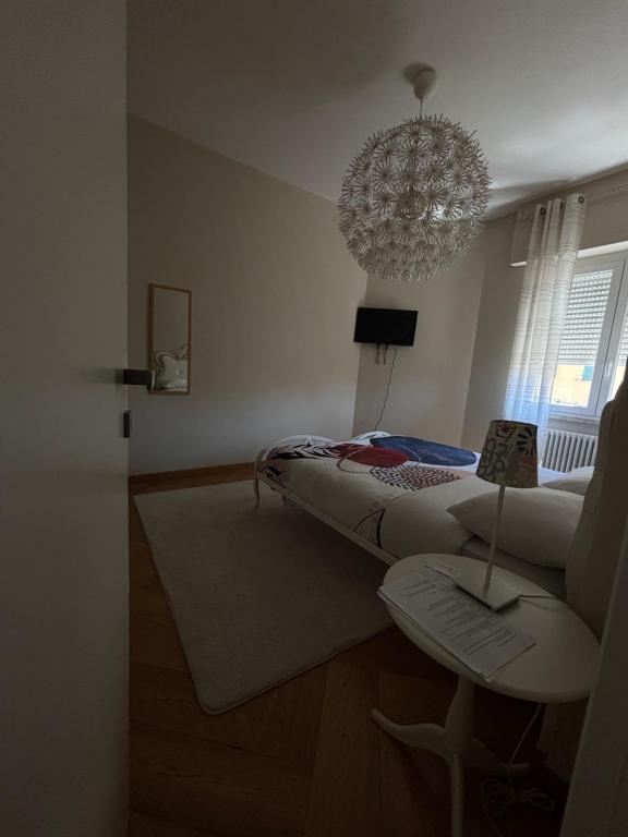 a bedroom with a bed and a chandelier at The Green Nest Perugia in Perugia