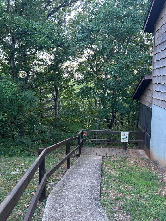 a wooden walkway leading to a house with a fence at Cabin Hilltop D on Meramec River in Steelville