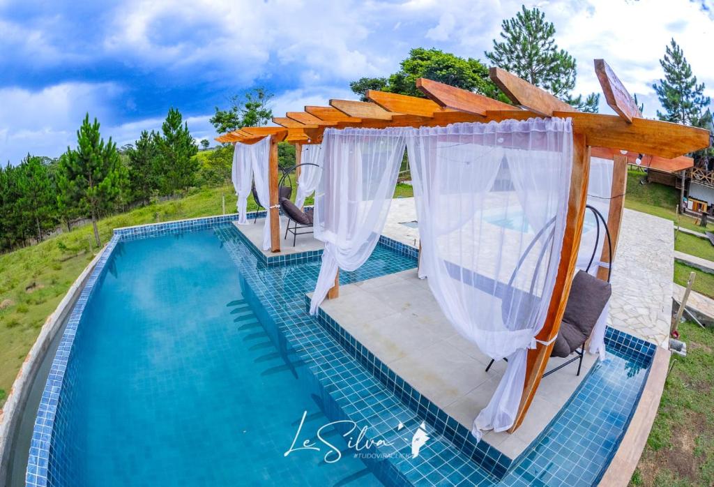 Draufsicht auf einen Pool mit einer Pergola über dem Schwimmbecken in der Unterkunft Chalé do Rista in Suzano