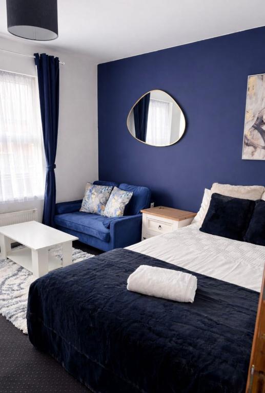 a bedroom with a bed and a couch and a mirror at Hotel Style Room within Reading in Reading