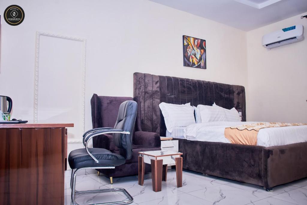 ein Schlafzimmer mit Bett, Stuhl und Schreibtisch in der Unterkunft Ozigrand Hotel in Benin-Stadt