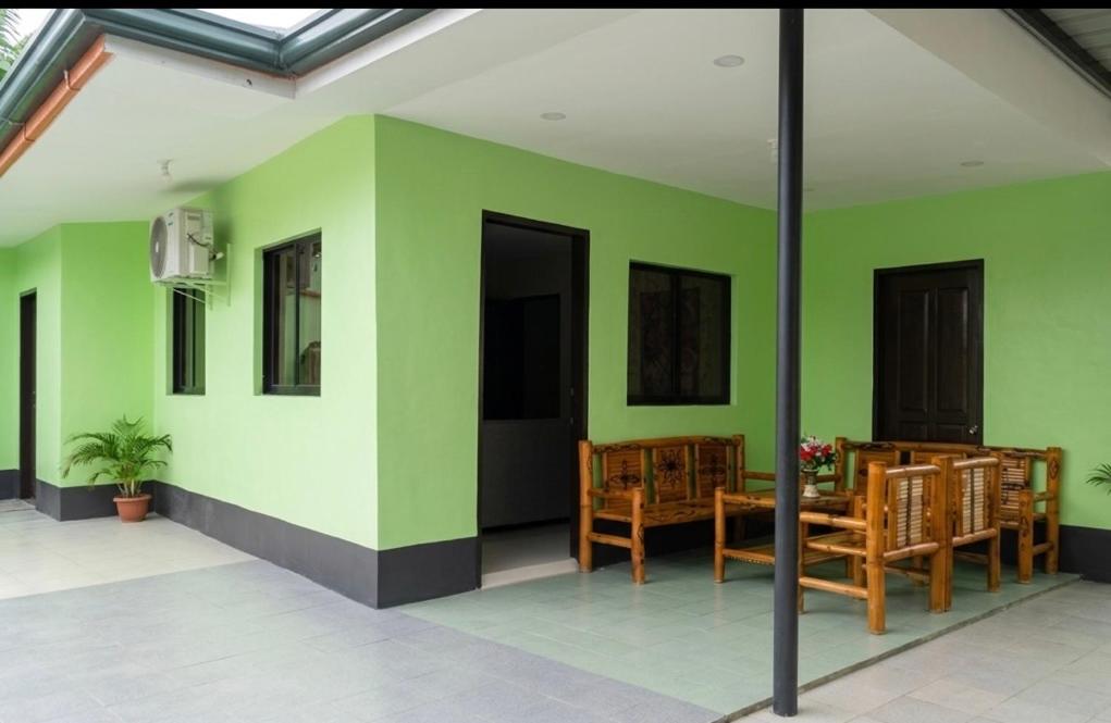 a room with green walls and a table and chairs at Moalboal Homestay VILLA in Tomonoy