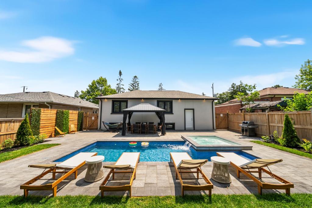 a backyard with a pool with chairs and a gazebo at 5 Bedroom Luxury Spa Escape with Pool & Jacuzzi in Toronto