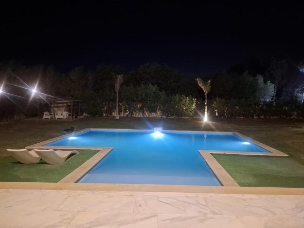 a large swimming pool at night with lights at Villa Casablanca in 6th Of October