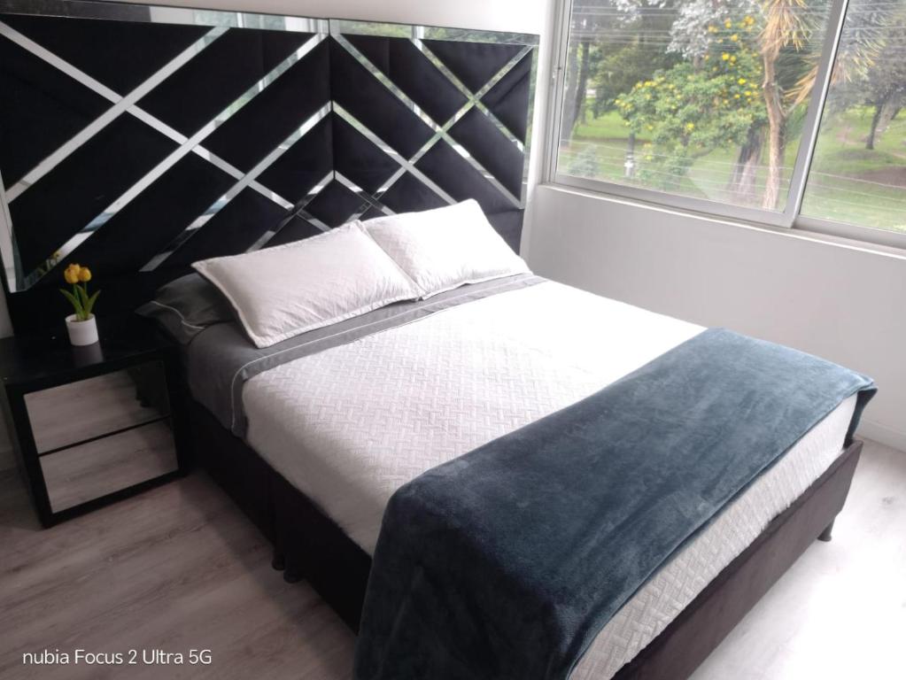 a bedroom with a bed and a large window at Room cerca al aeropuerto #2 in Bogotá