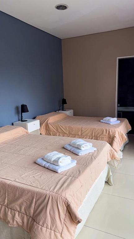 two beds in a room with towels on them at Casa Olivia in Luján