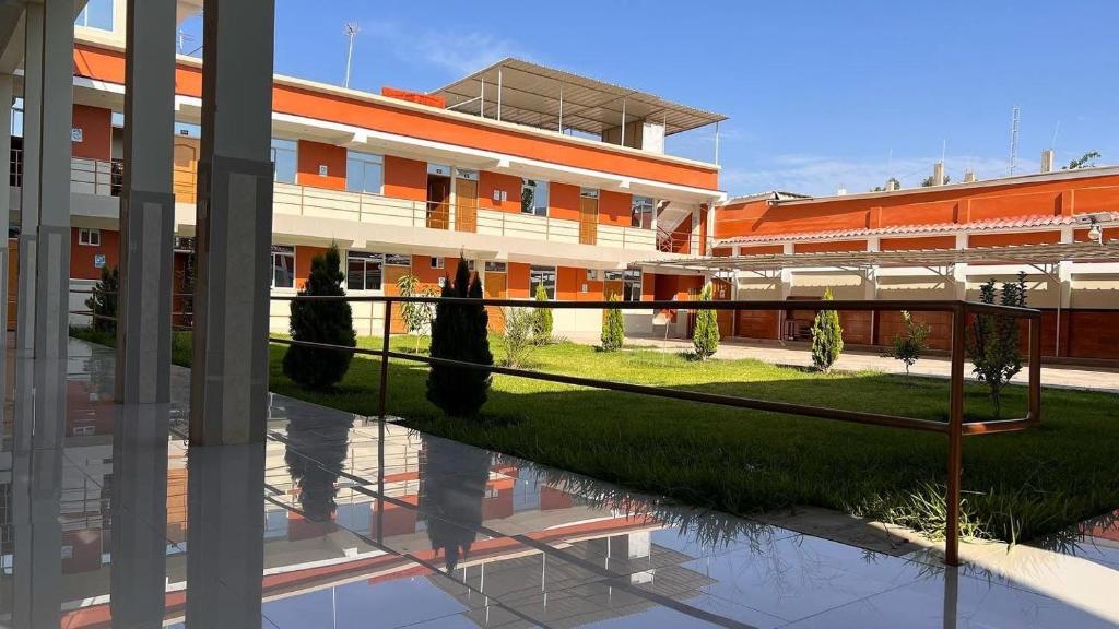 a rendering of a building with a grass courtyard at Hostal Bon in Nazca