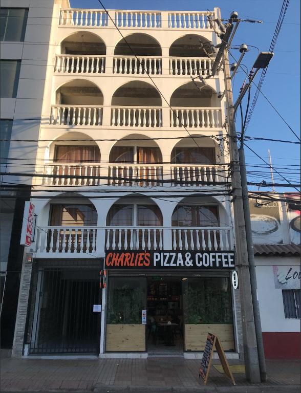 a building with a pizza and coffee sign on it at Hotel Simon II in Antofagasta