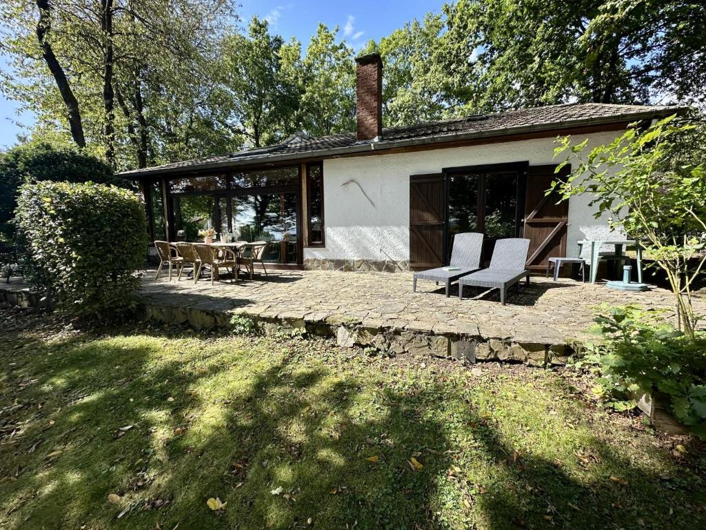 a house with a patio with two chairs and a table at Boogie House in Rendeux