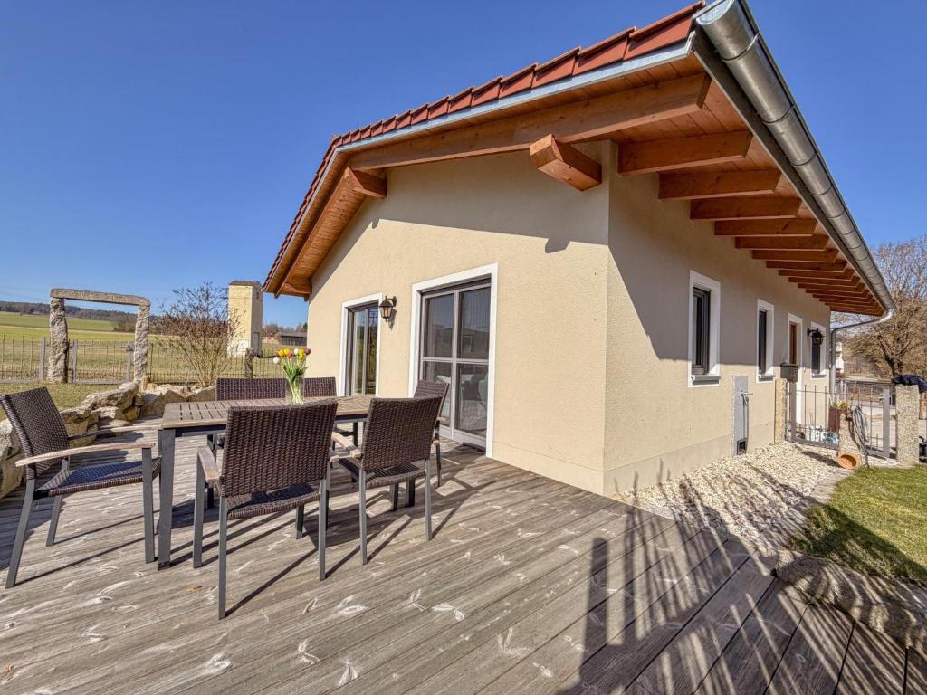 eine Terrasse mit Stühlen und einem Tisch und ein Haus in der Unterkunft Fonse in Pettendorf
