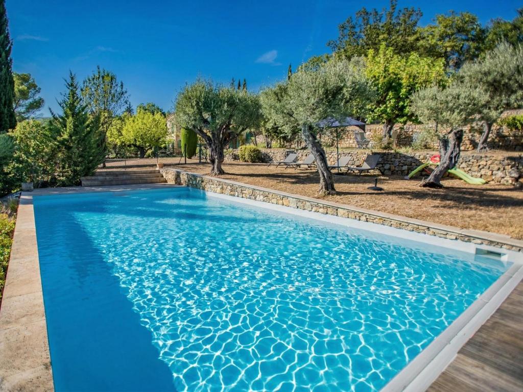 a swimming pool in a yard with trees at Le Mas dormant in Fayence