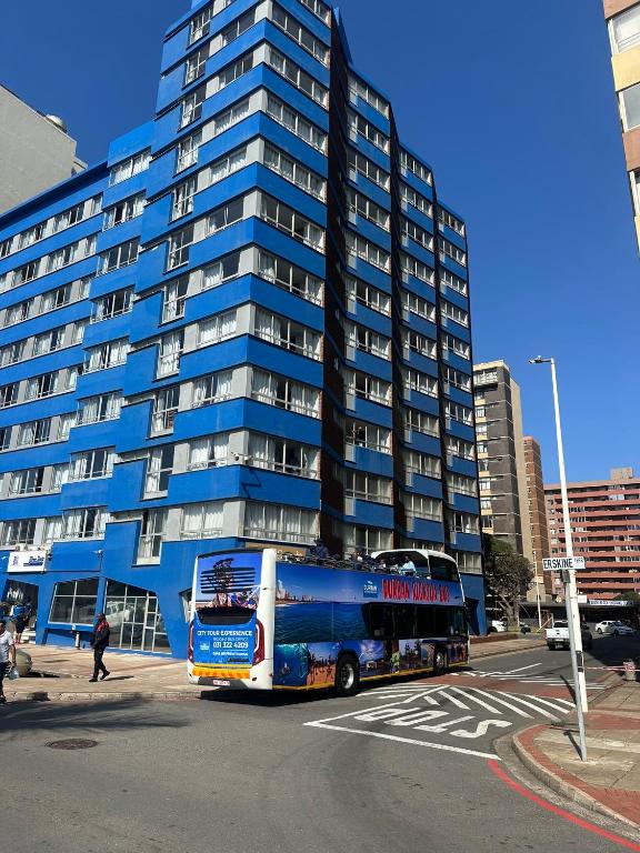 a bus is parked in front of a tall building at SolSands Hotel & Self-Catering in Durban