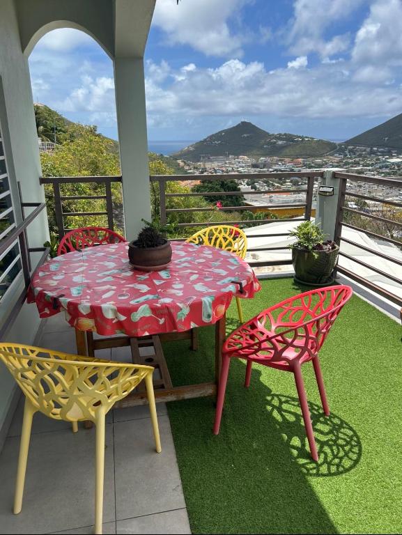 a table and chairs on a balcony with a view at B's Hidden Paradise in Philipsburg