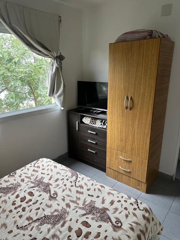 a bedroom with a bed and a dresser and a window at Mica in Salta