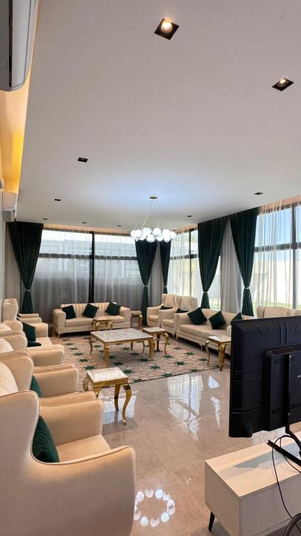 a living room with couches and a tv in a building at شاليه ماديرا in Hail