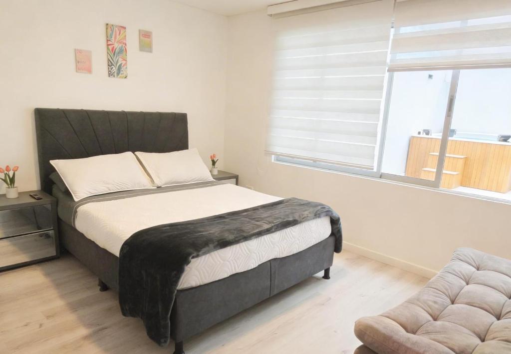 a bedroom with a bed and a chair and a window at Room cerca al aeropuerto #4 in Bogotá