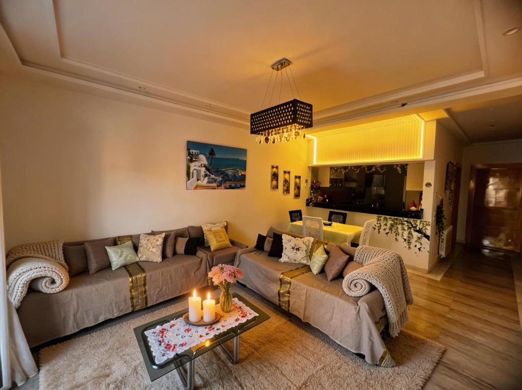 a living room with two couches and a table with candles at Dar Al Yaqout in Le Kram