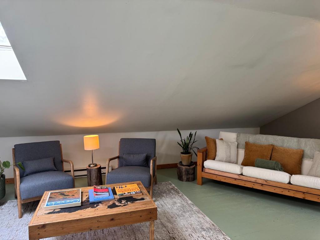 a living room with a couch and two chairs and a coffee table at Kinsol Hideaway in Shawnigan Lake