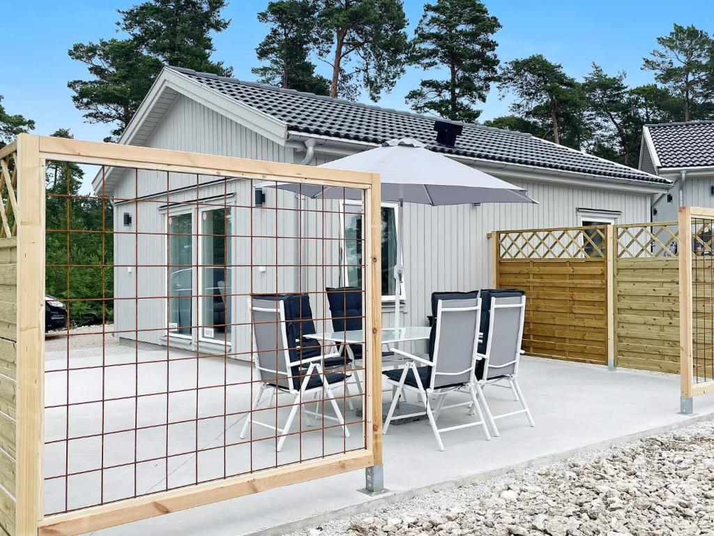 a screened in deck with chairs and an umbrella at 4 star holiday home in Klintehamn in Klintehamn