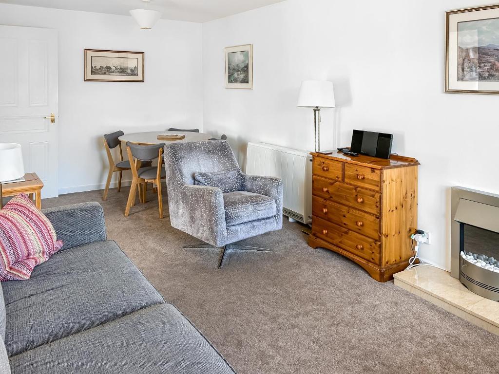 a living room with a couch and a chair and a table at Glenrothay in Aviemore