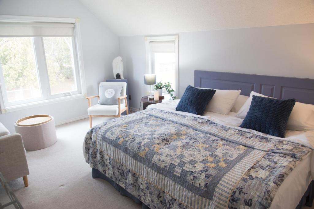 a bedroom with a large bed and a chair at Gypsy by the Lake Bed and Breakfast in Sutton